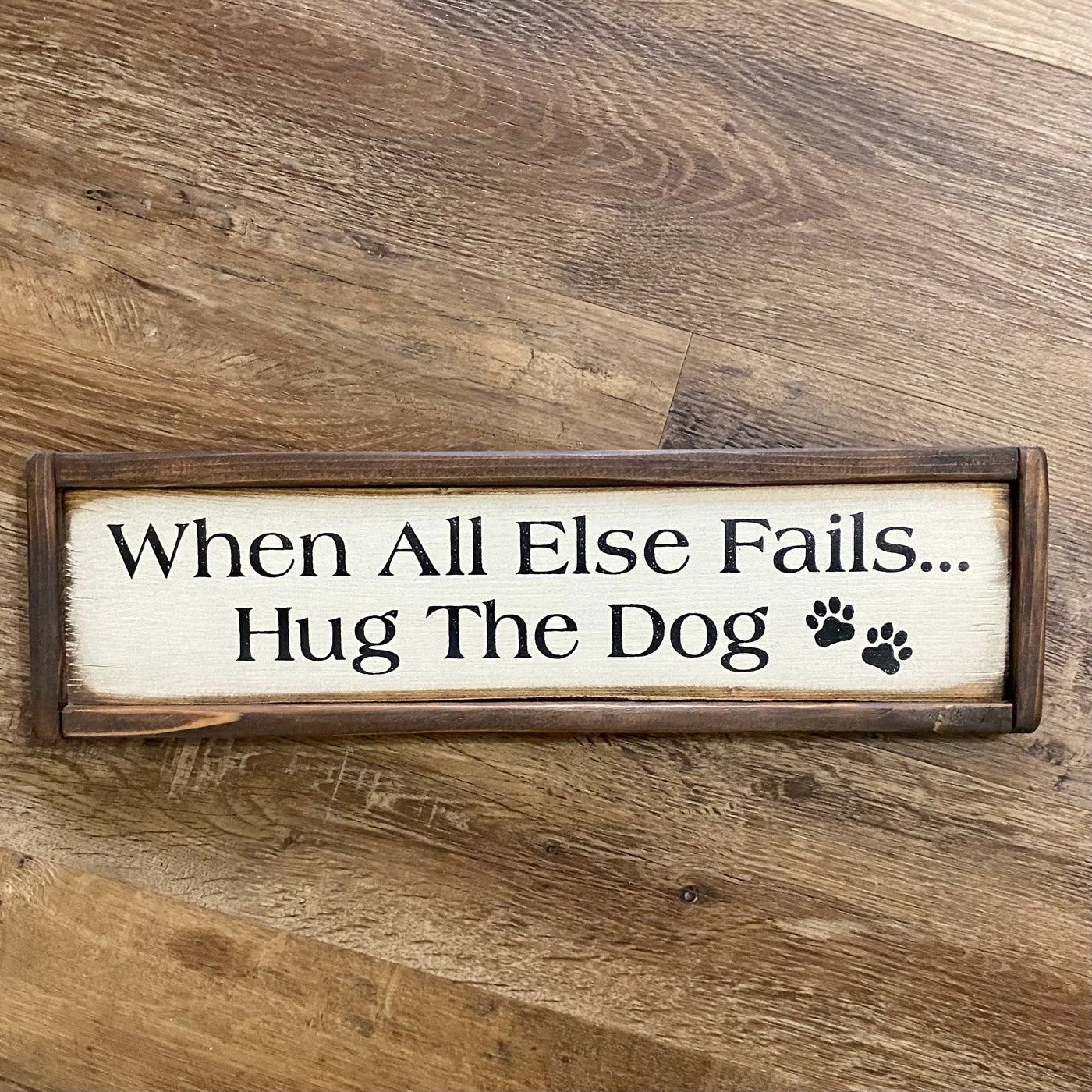 Handmade sign reads When All Else Fails Hug The Dog with paw print accents