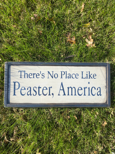 Handmade wood sign reads There’s No Place Like Peaster, America