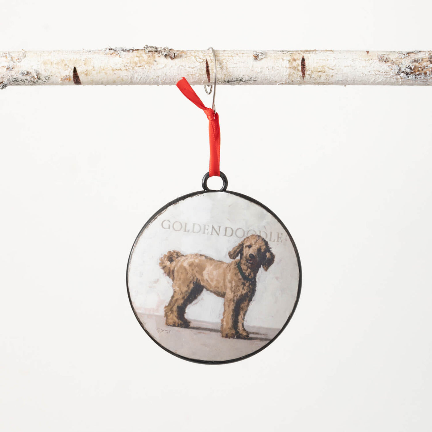 Round metal ornament with a portrait of a Goldendoodle on the front and a red back. Comes with a red ribbon for hanging.
