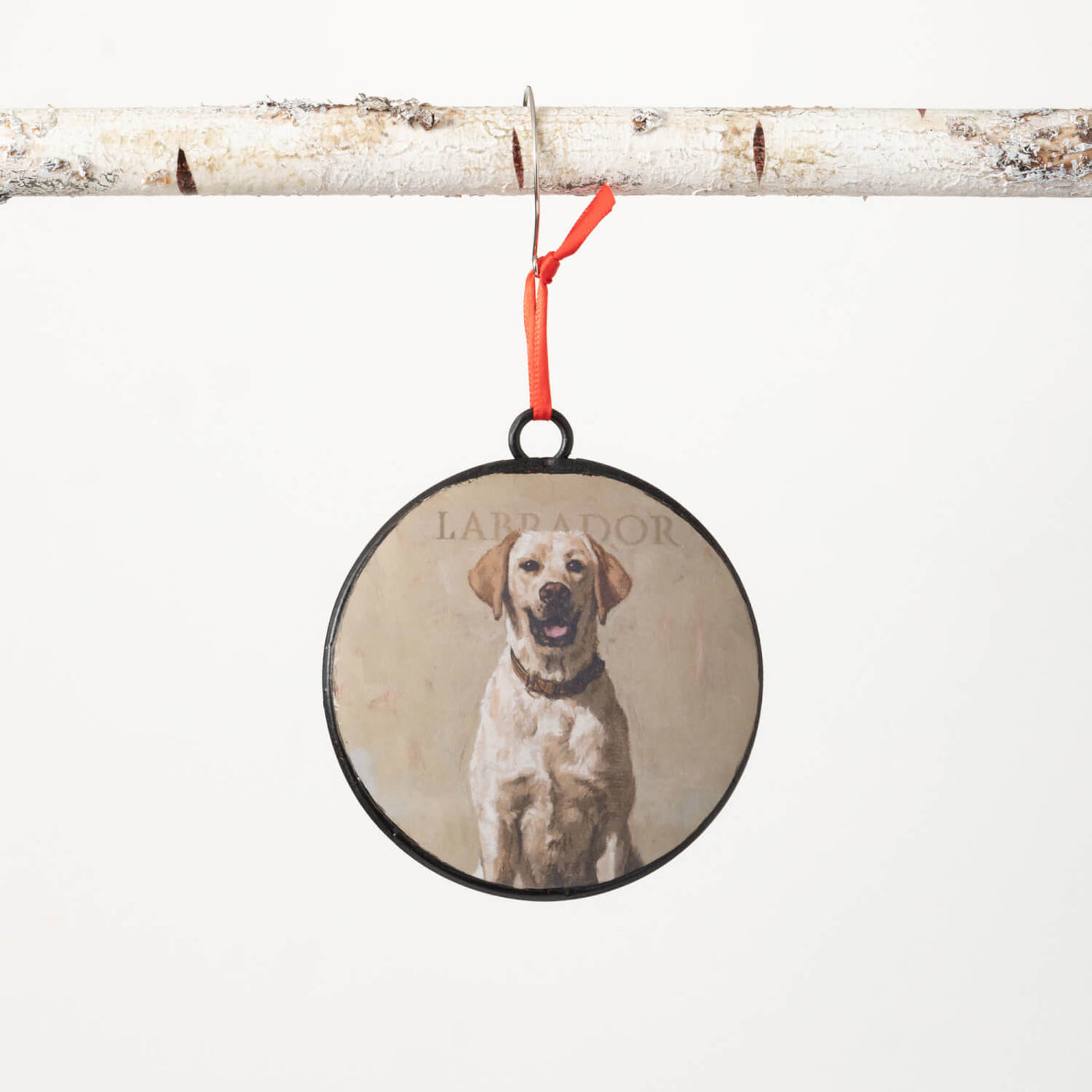 Round metal ornament with red ribbon and a portrait of a yellow lab on the front. Back is red. 