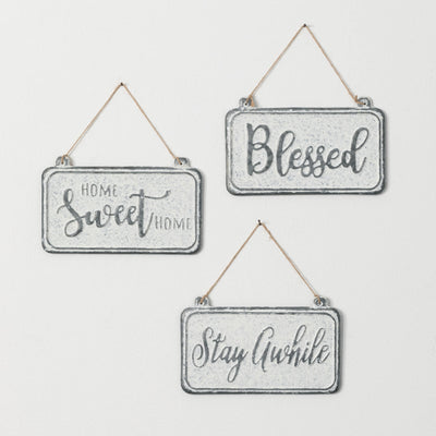 Three metal signs on rope hangers read home sweet home, blessed, and stay awhile