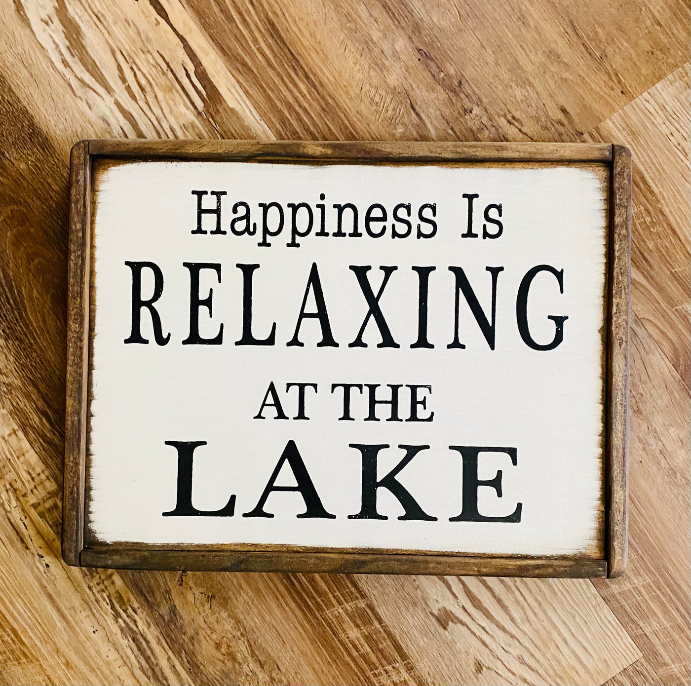 Handmade wooden lake sign reads Happiness Is Relaxing At The Lake