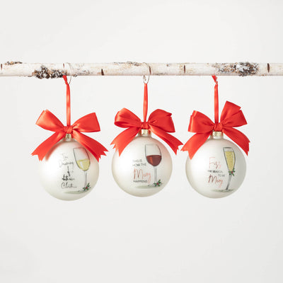 Three ornaments I'm dreaming of a white wine Christmas", "This is how the merry happens", and "Fizz the season to be merry" adorn white glass ball ornaments, topped with satin red ribbons.