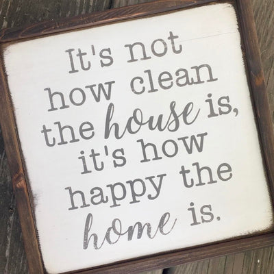Handmade wood sign reads It’s not how clean the house is, it’s how happy the home is.