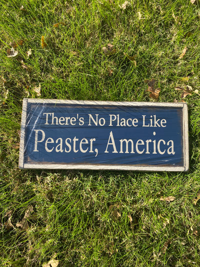Handmade wood sign read There’s No Place Like Peaster, America