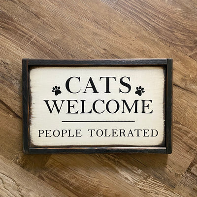 Handmade wood sign reads cats welcome people tolerated with painted paw print accents