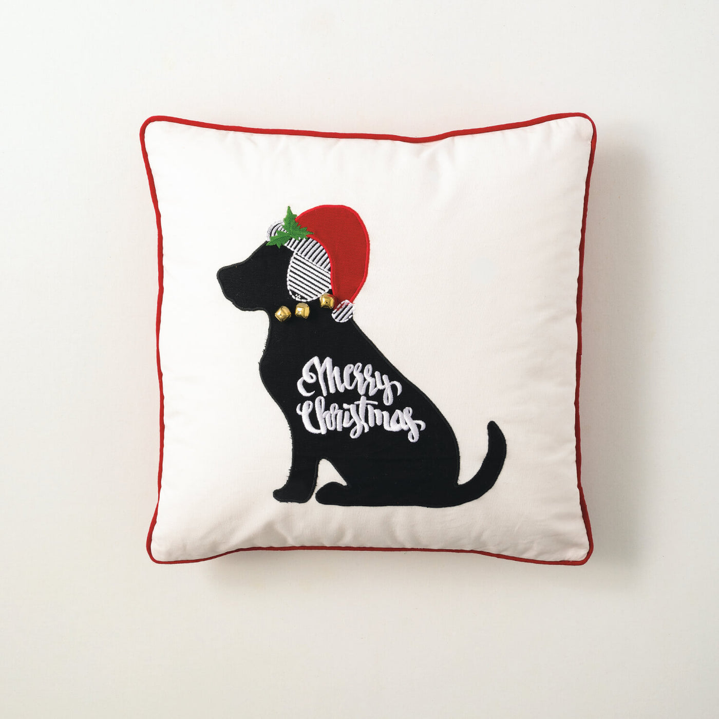 White throw pillow with embroidered black dog in a Santa hat and jingle bell collar reads Merry Christmas