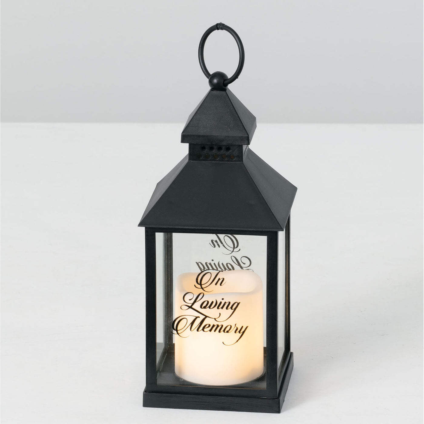 Black lantern with flameless pillar candle that reads In loving memory