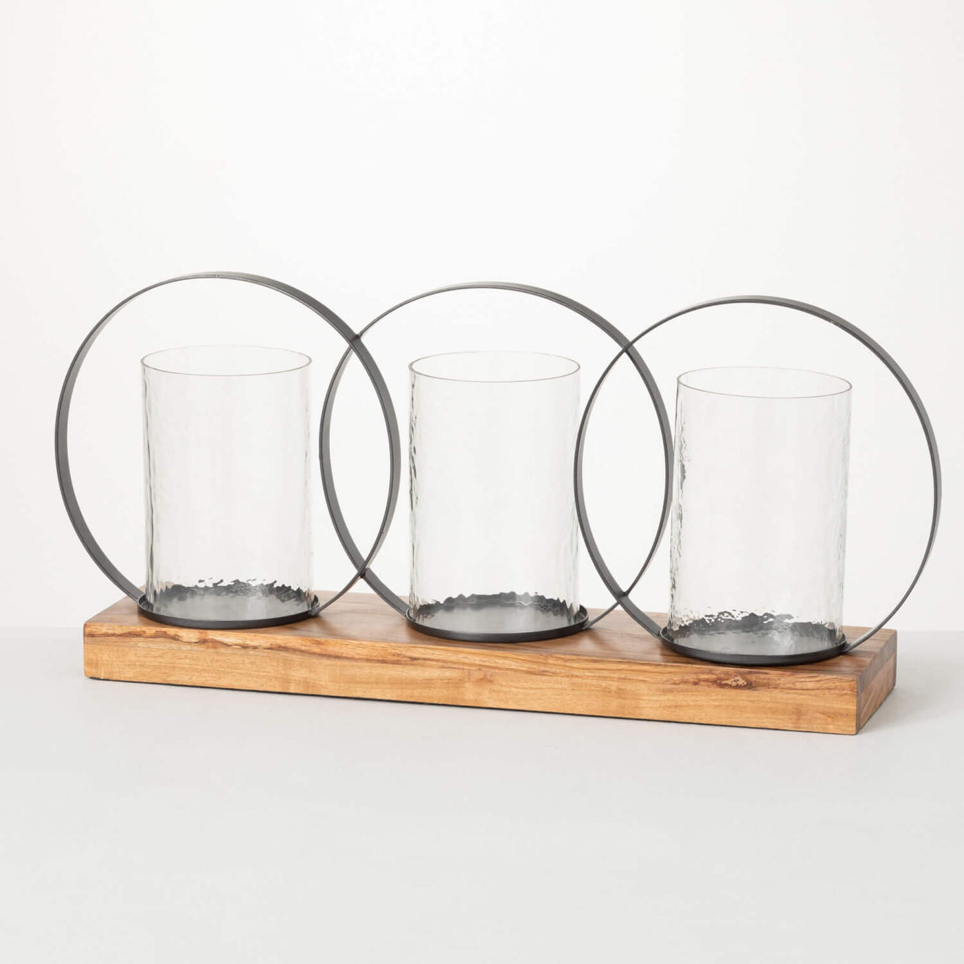 modern triple pillar candle holder Featuring a wooden base, glass sleeves and circle hoop accents