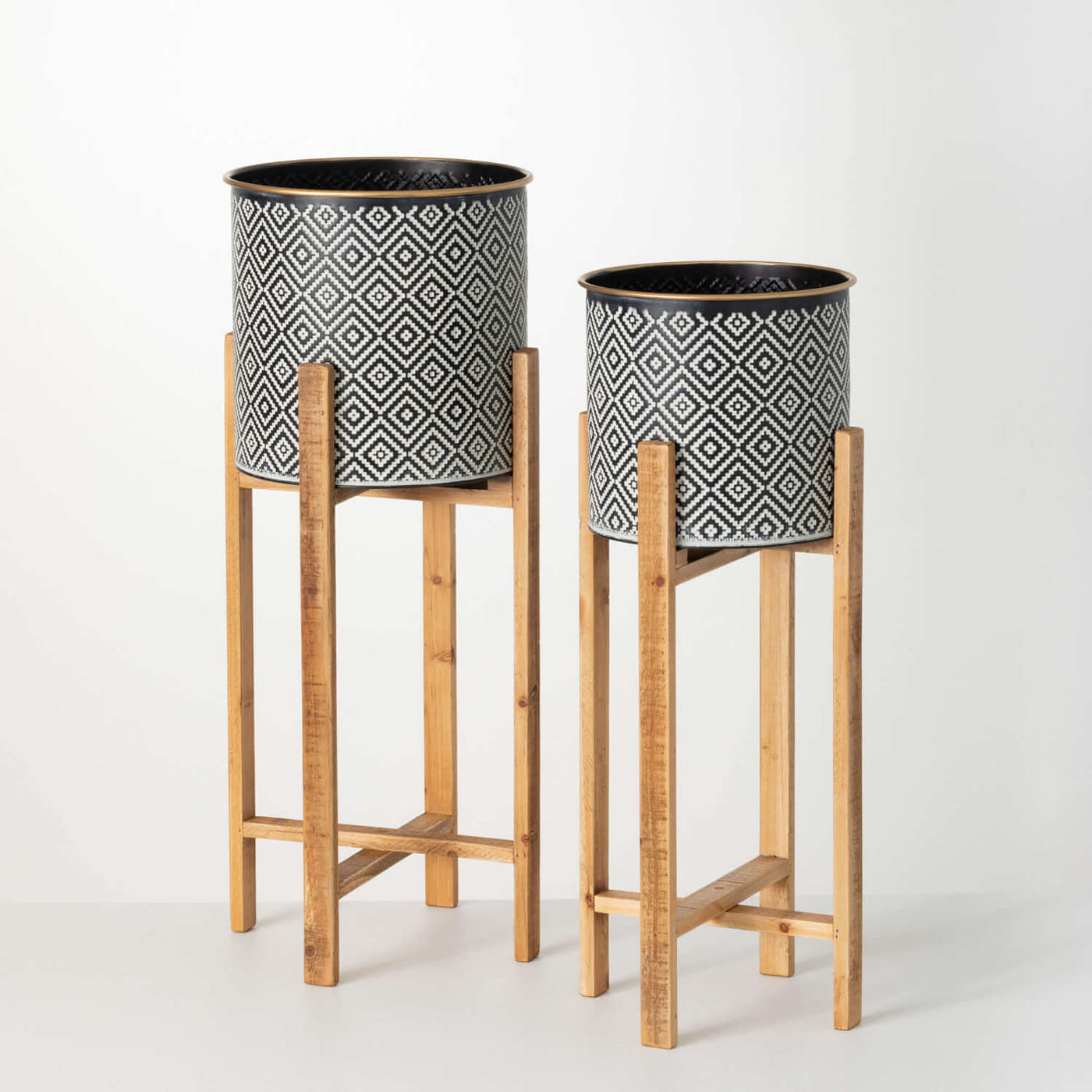 Black and white patterned metal planters on wooden stands