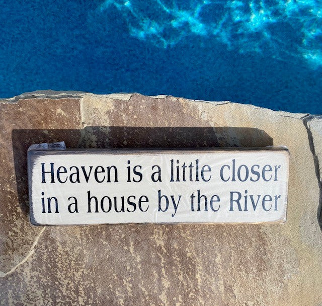 Handmade wood sign reads Heaven is a little closer in a house by the River