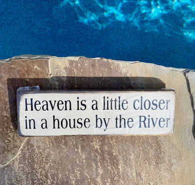 Handmade wood sign reads Heaven is a little closer in a house by the River