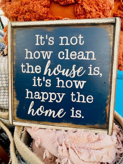 Handmade wood sign reads It’s not how clean the house is, it’s how happy the home is