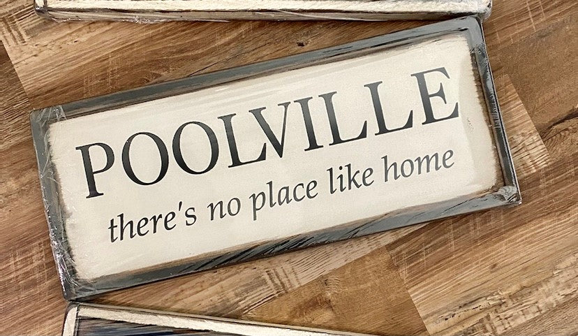 Handmade wood sign reads Poolville there’s no place like home