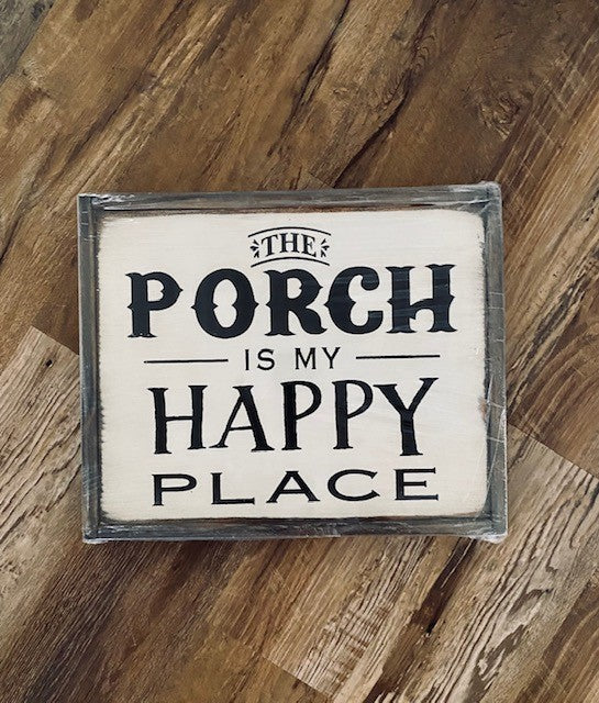 Wood sign with white background and black lettering reads the porch is my happy place