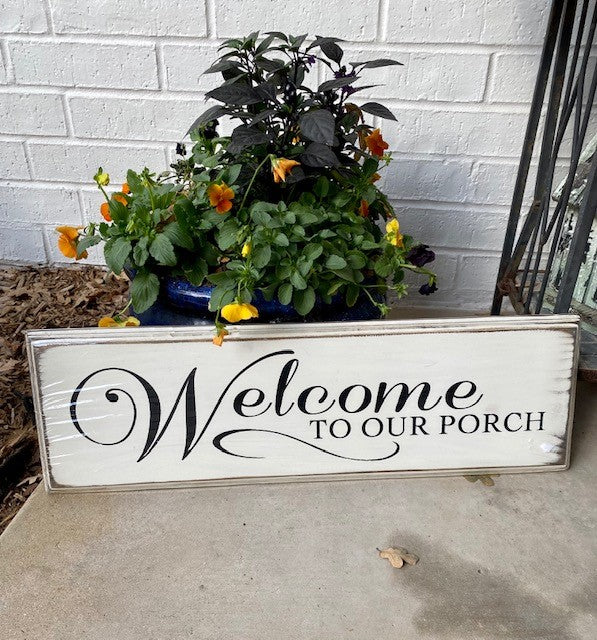 Handmade wood sign with decorative edge reads Welcome To Our Porch