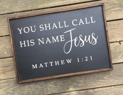 Wooden sign reads you shall call his name Jesus. Matthew 1:21