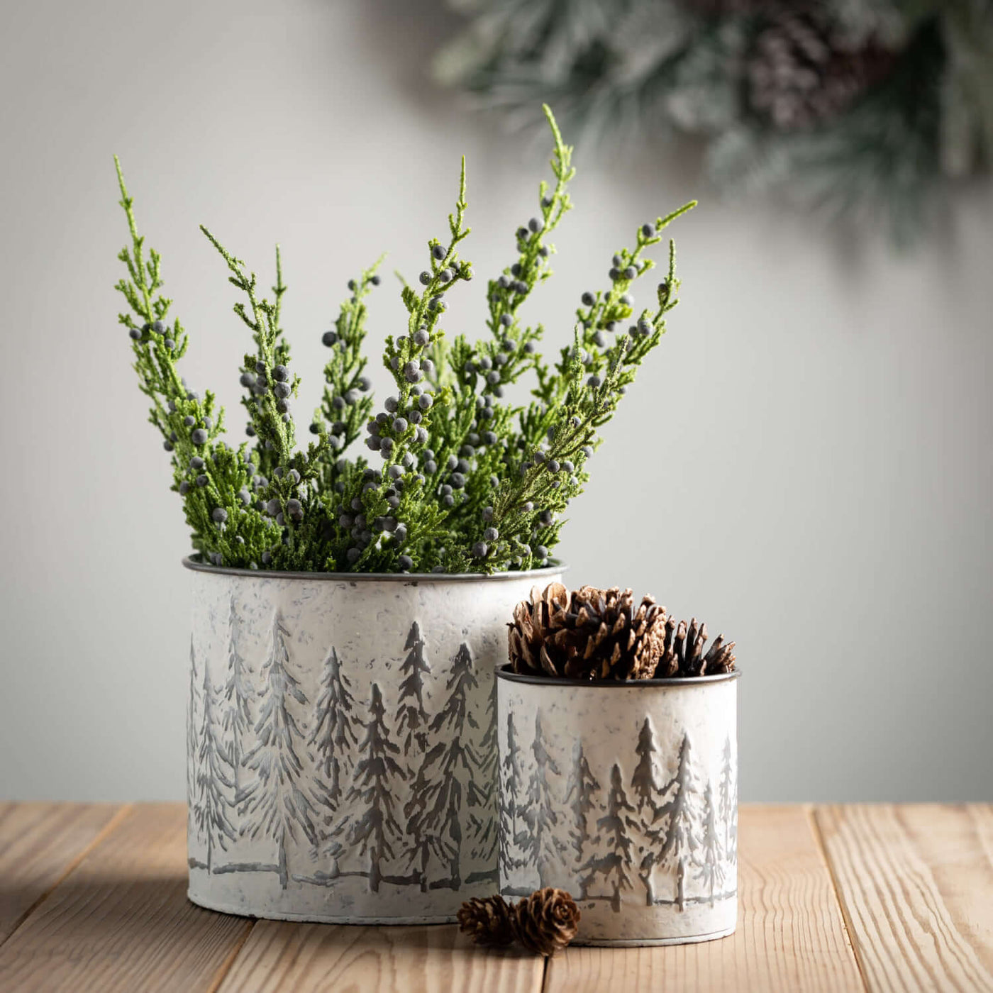 Metal planters with wintery evergreen tree embossed scenery,