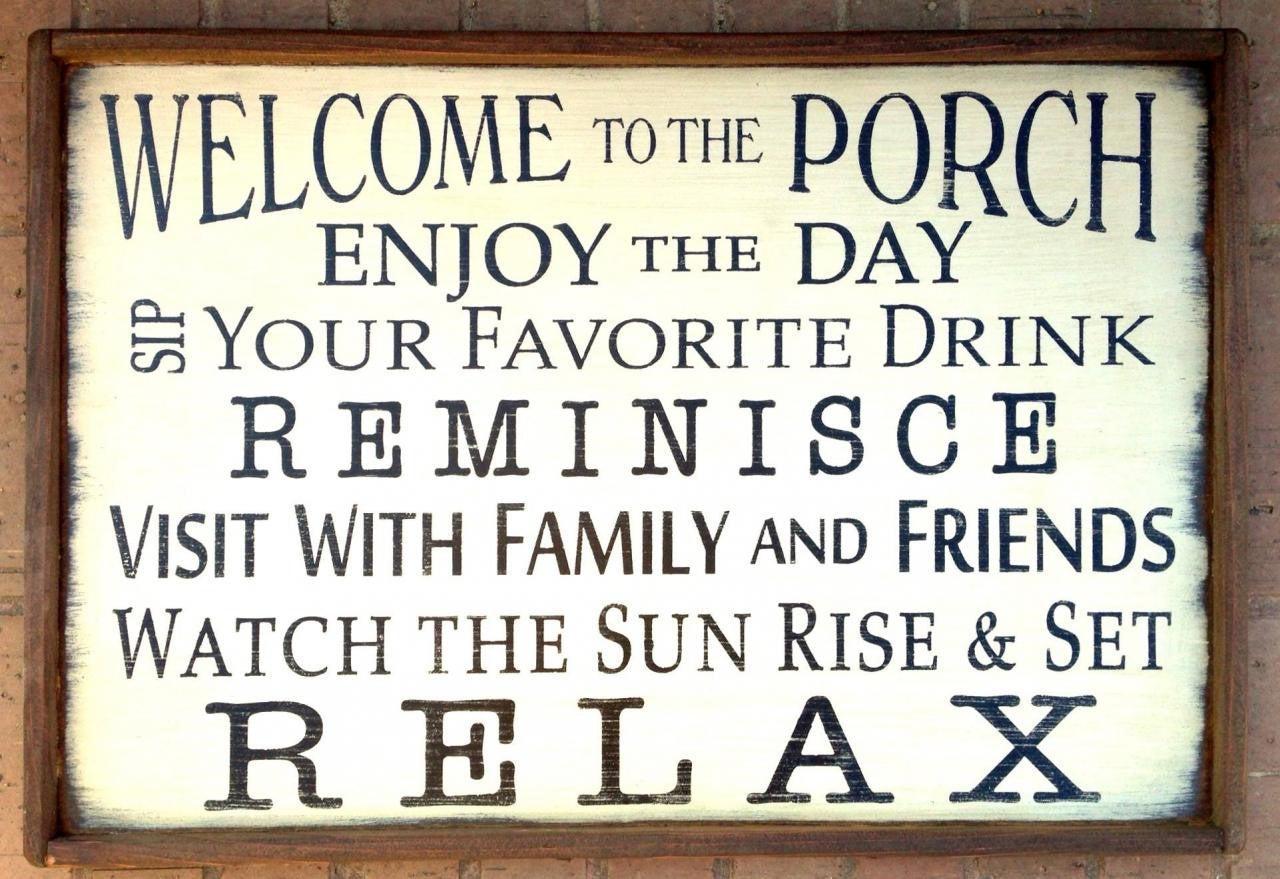 Handmade wooden porch sign reads Welcome to the Porch, Enjoy the Day, Sip Your Favorite Drink, Reminisce, visit with Family and Friends, watch the Sun Rise and set, RELAX